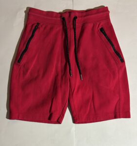 Red athletic shorts with black drawstring and zippered pockets.
